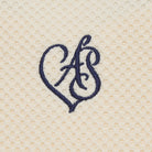 Navy blue embroidered monogram on beige textured fabric