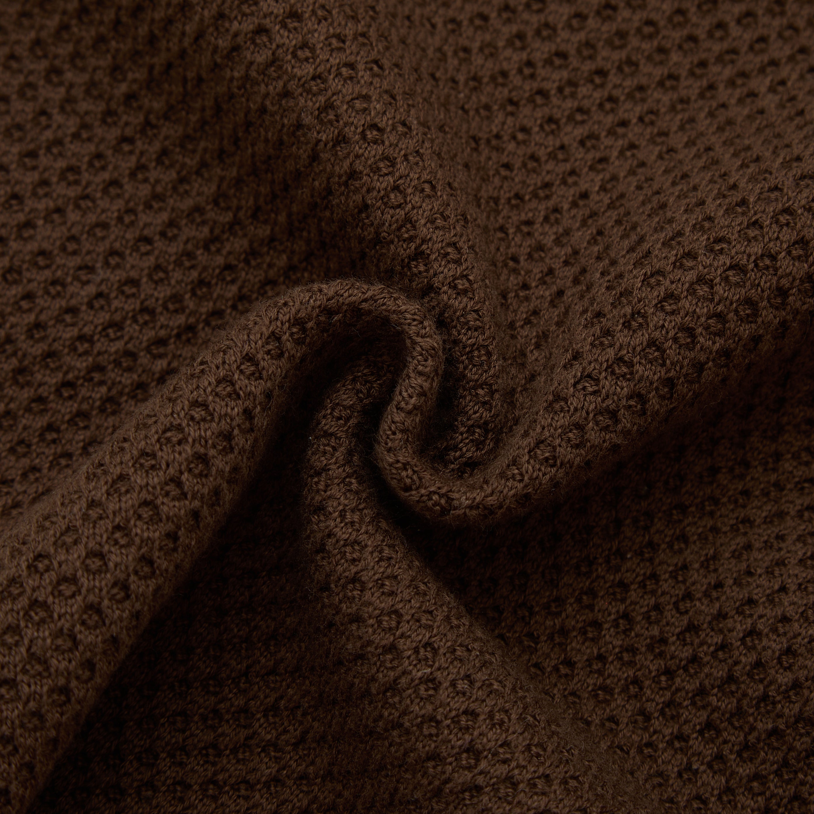 Close-up of brown textured fabric with a slight wave.