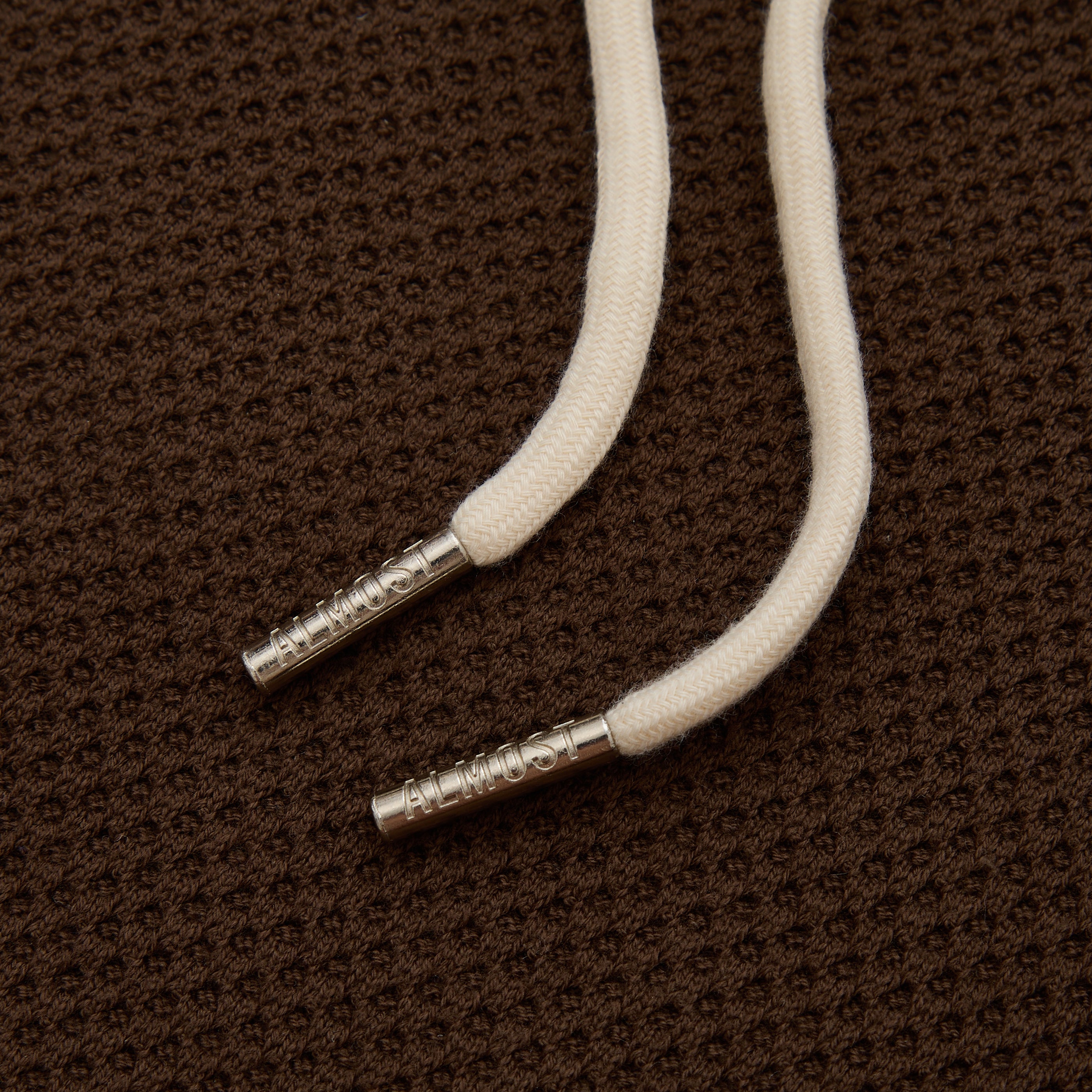 White cord with metal ends on a brown textured background