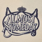 Embroidered text 'ALMOST SOMEDAY' with decorative elements on a beige background