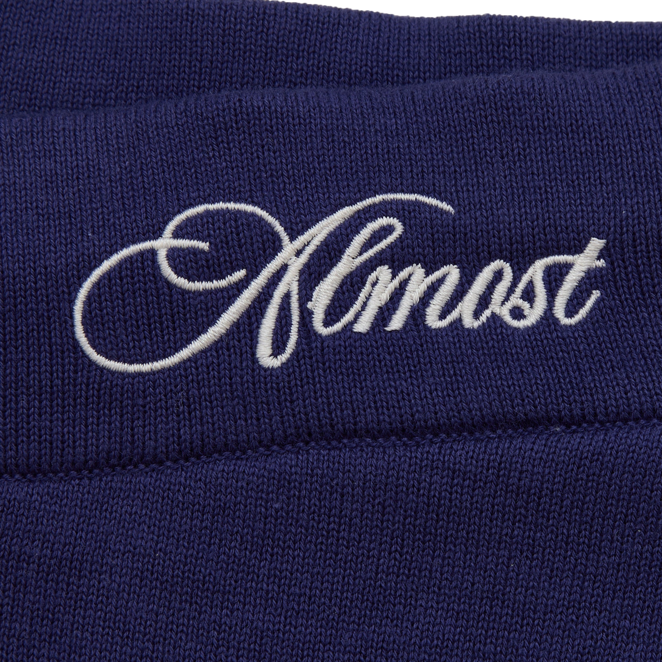Navy blue fabric with 'Almost' embroidered in white thread