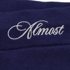 Navy blue fabric with 'Almost' embroidered in white thread