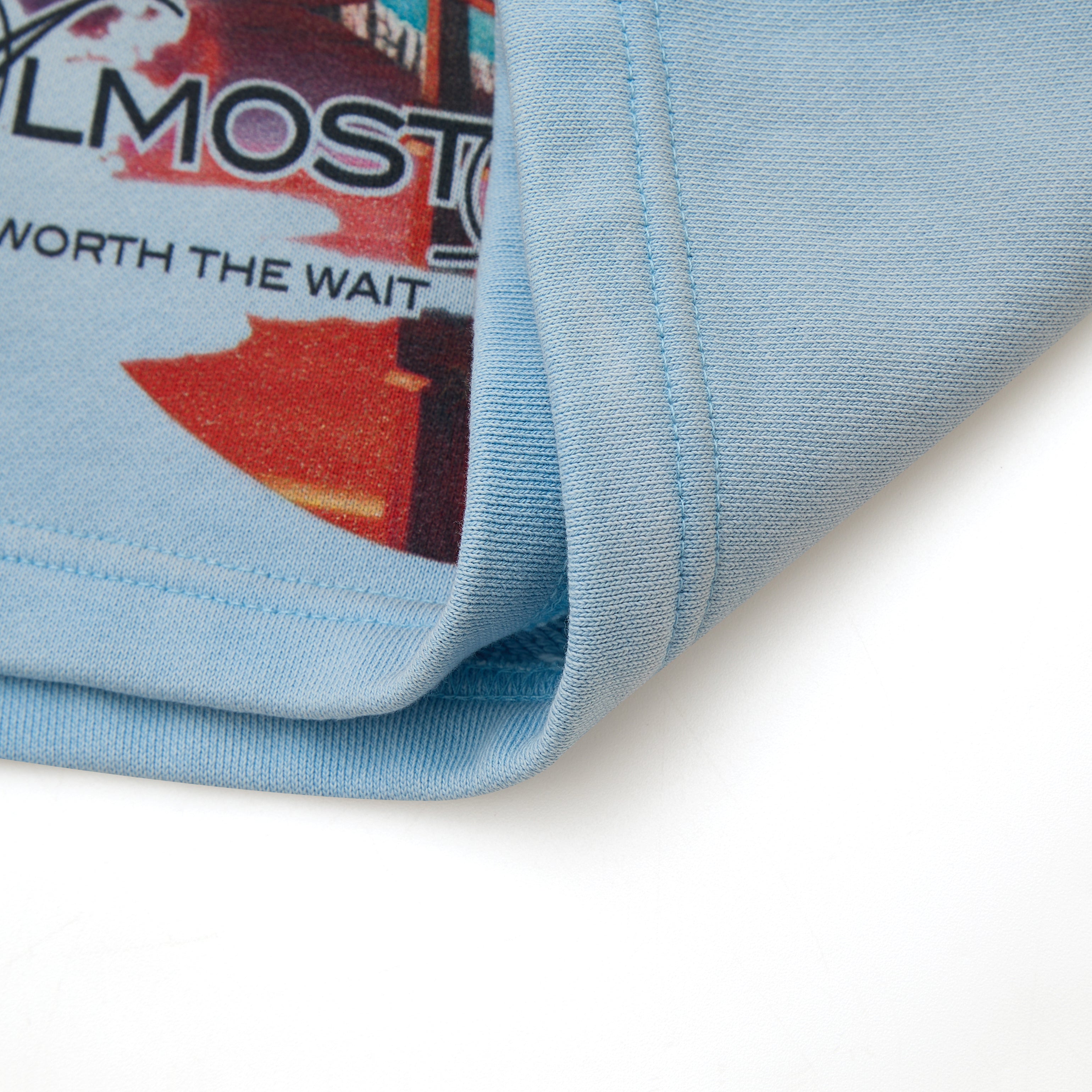 Close-up of a blue sweatshort fabric with text and graphics on a white background