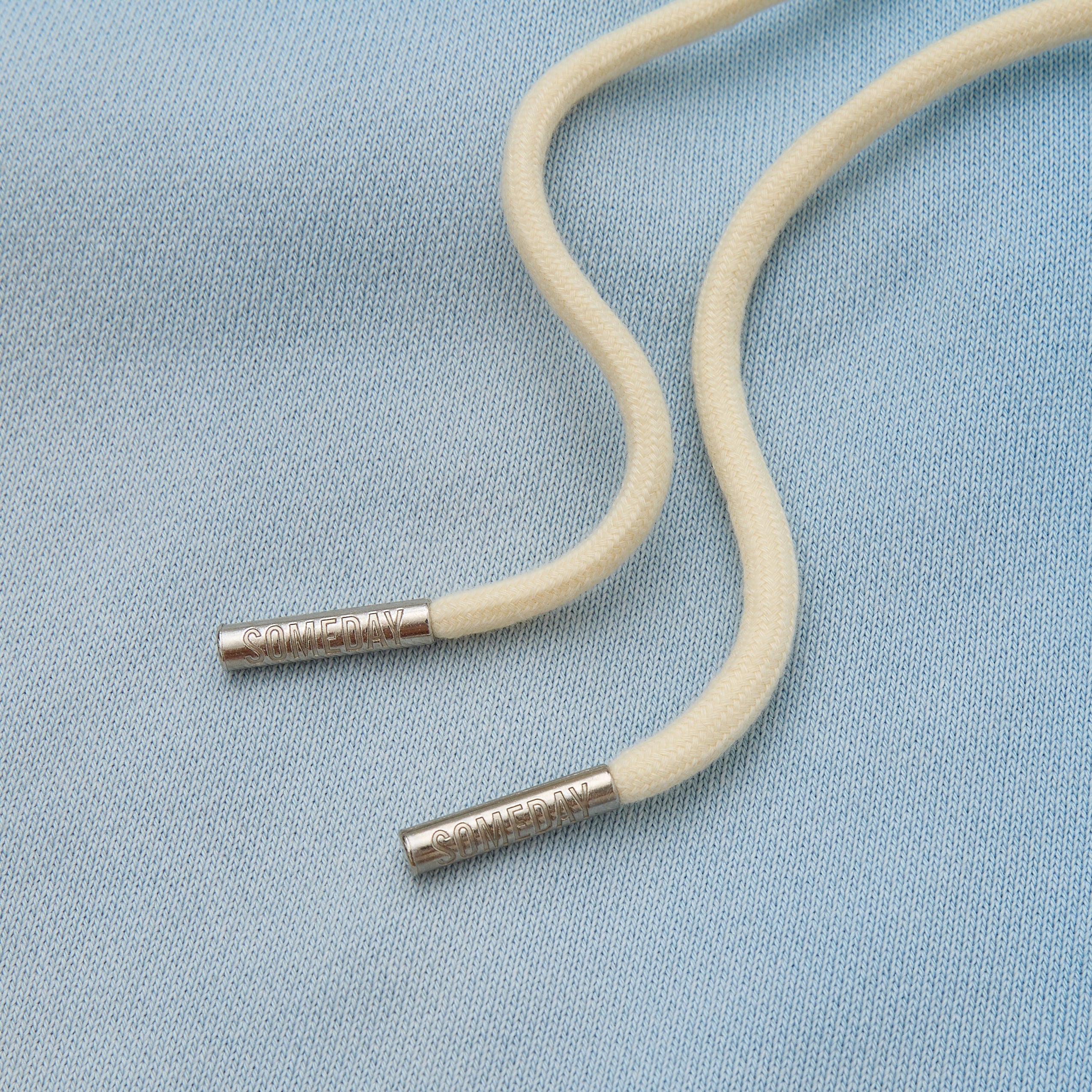Beige cord with metal ends on a light blue background