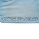Light blue fabric with text 'Better in hell with me, than alone in heaven' embroidered on it.