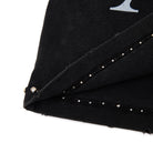Close-up of a black fabric with silver studs on a white background