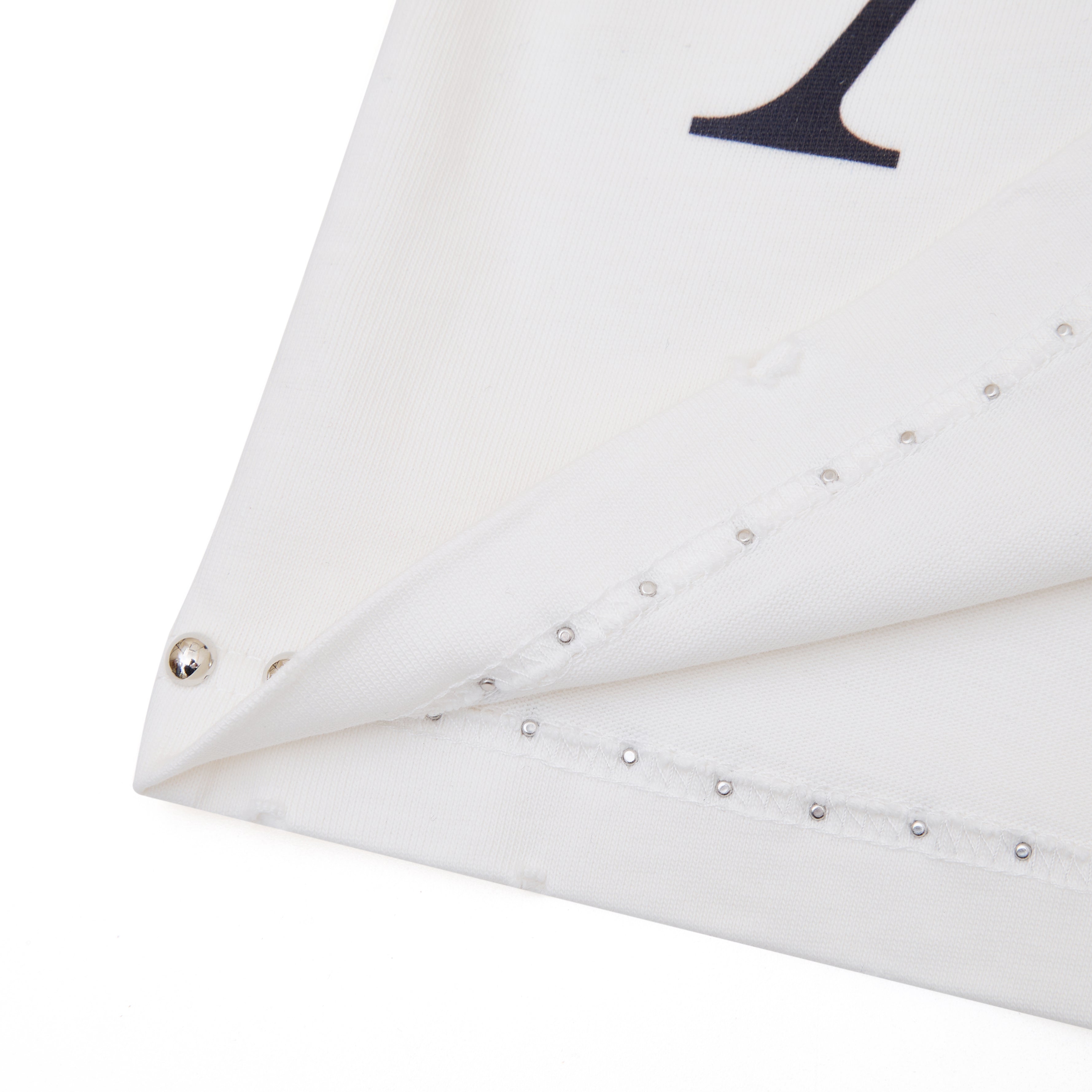 White fabric with decorative studs on a white background