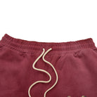 Maroon terry shorts with a beige drawstring on a white background