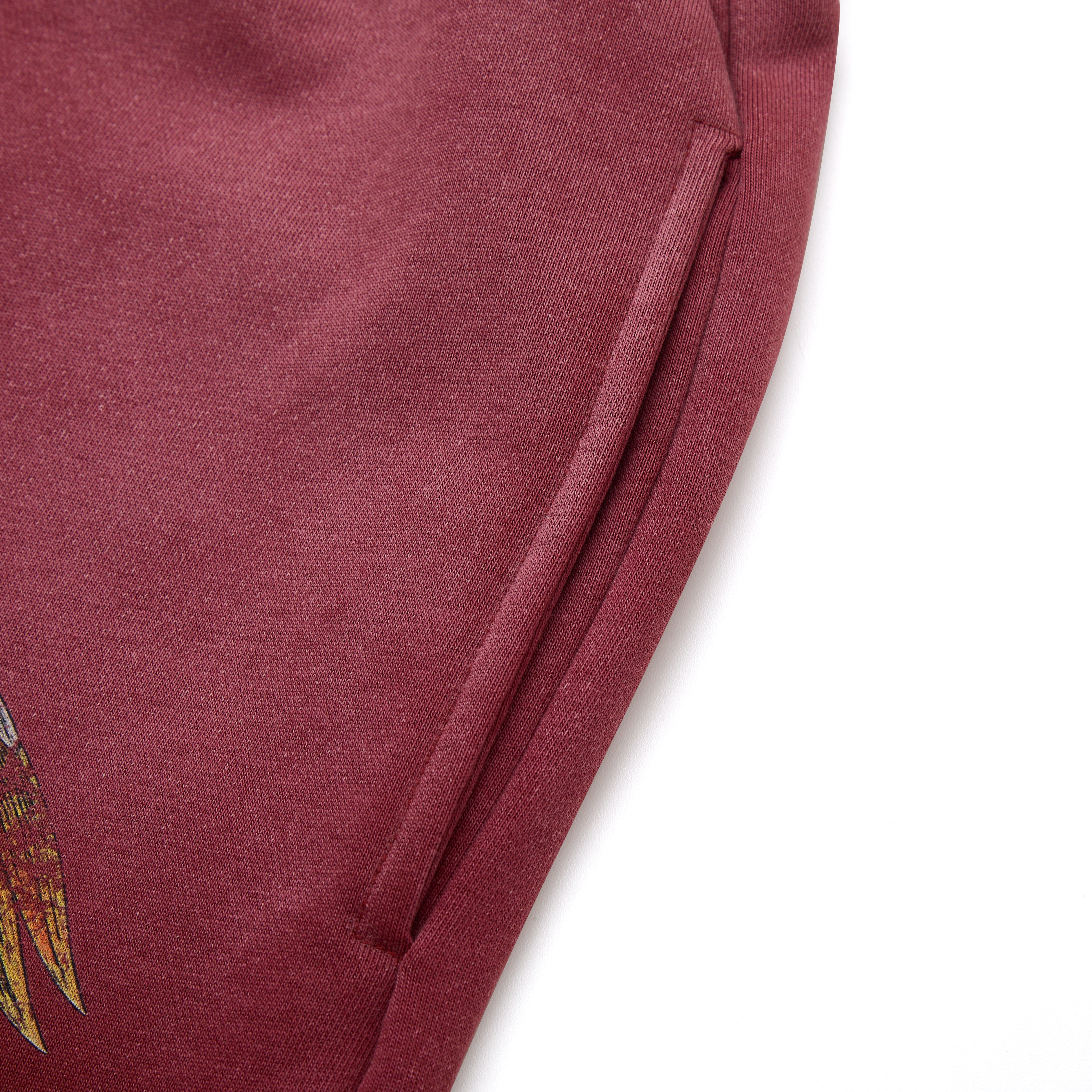 Close-up of a maroon fabric with a small embroidered design on a white background