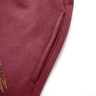 Close-up of a maroon fabric with a small embroidered design on a white background