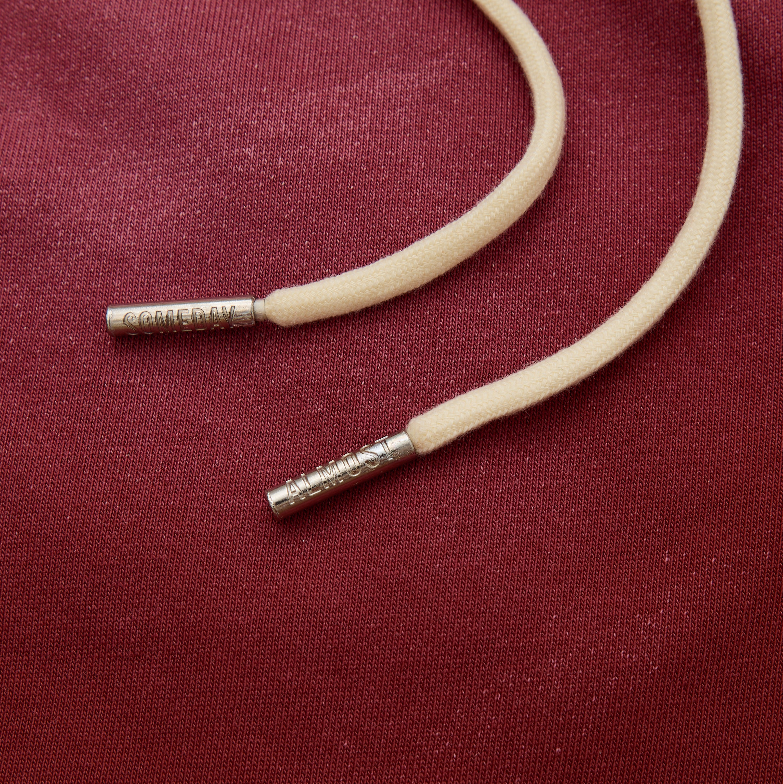 Beige cord with silver clasp on a red fabric background