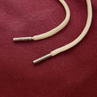 Beige cord with silver clasp on a red fabric background