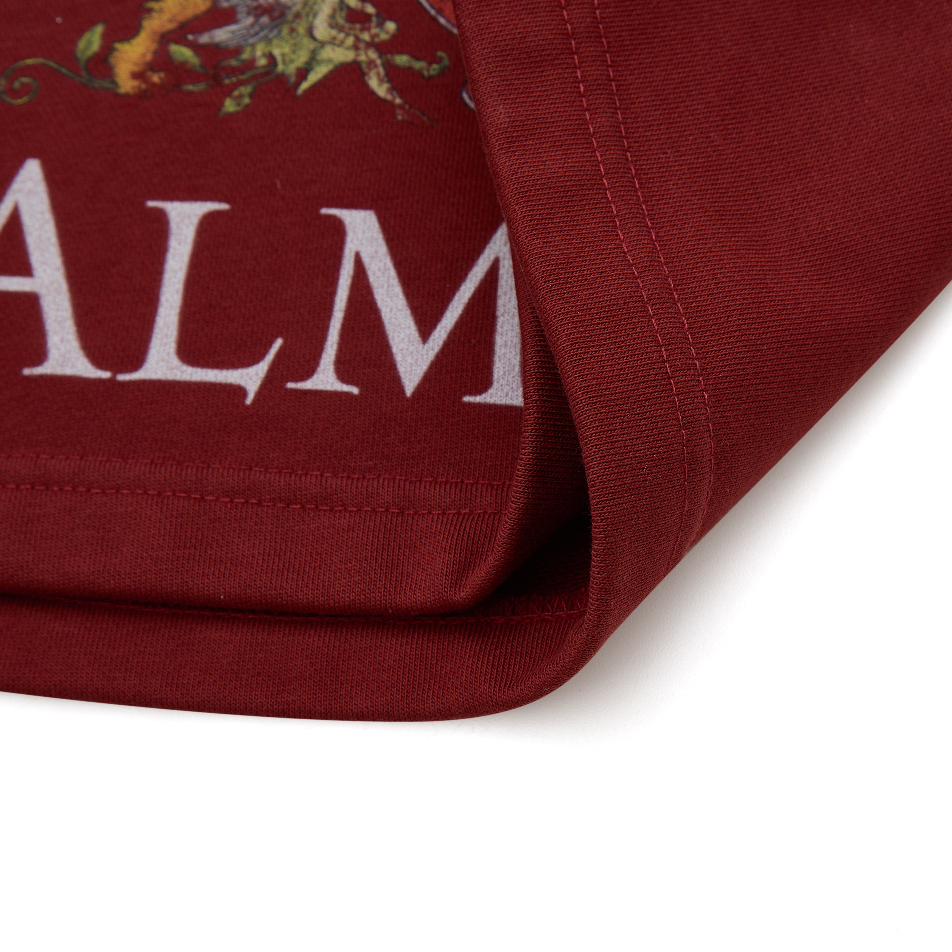 Close-up of a red fabric with 'ALMOST' branding on a white background