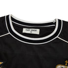 Black shirt with white trim and 'Almost Someday' label on a white background
