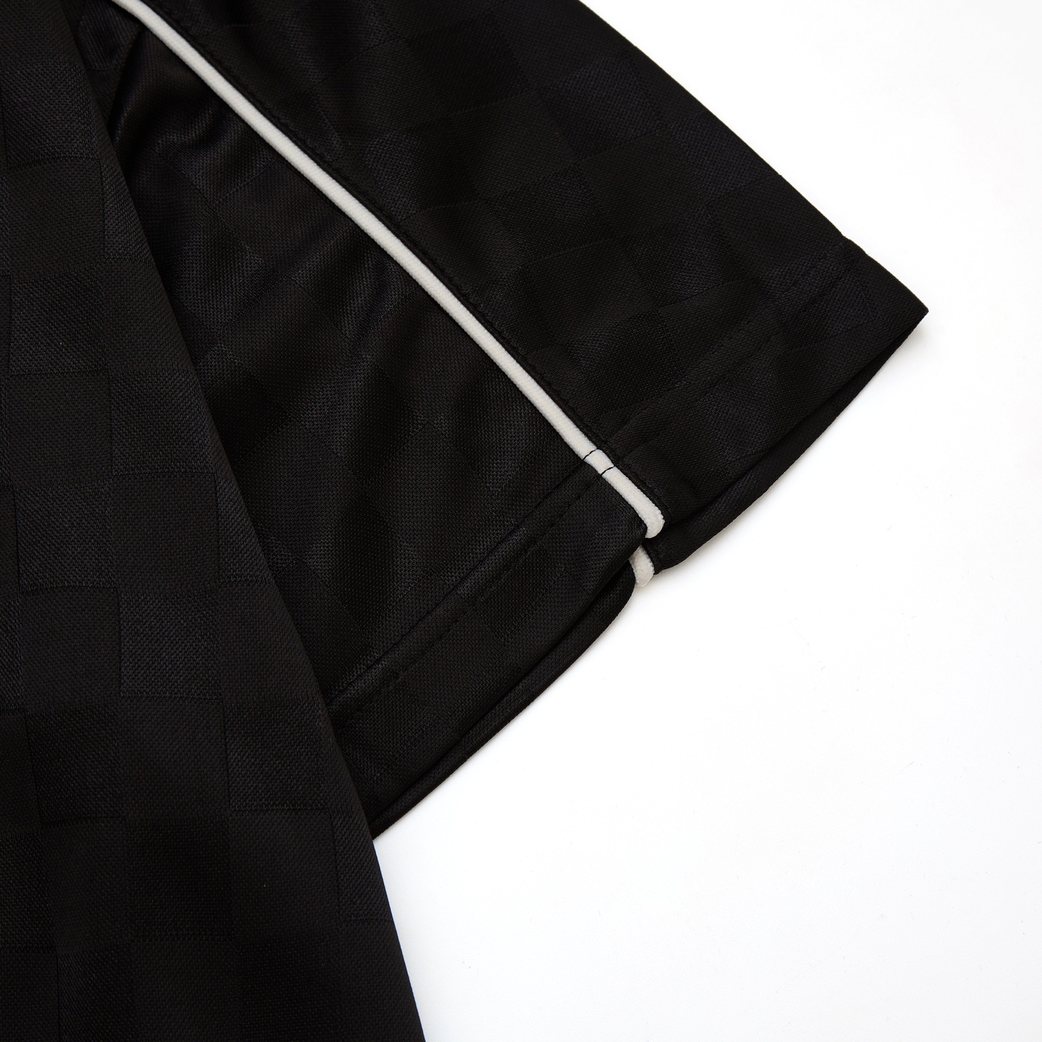 Black fabric with white piping on a white background