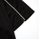Black fabric with white piping on a white background