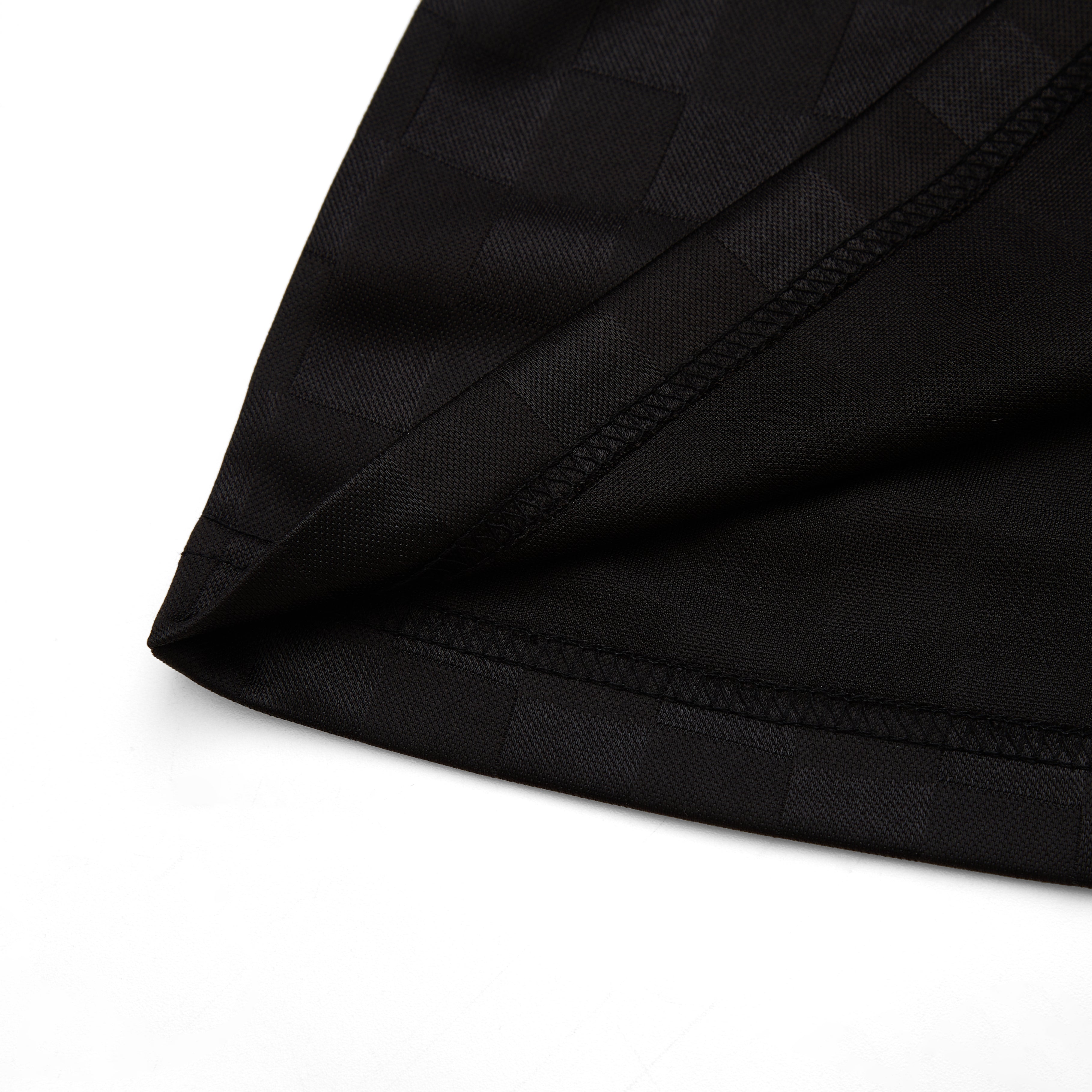 Close-up of black fabric with a brand label on a white background