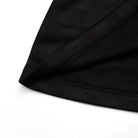 Close-up of black fabric with a brand label on a white background
