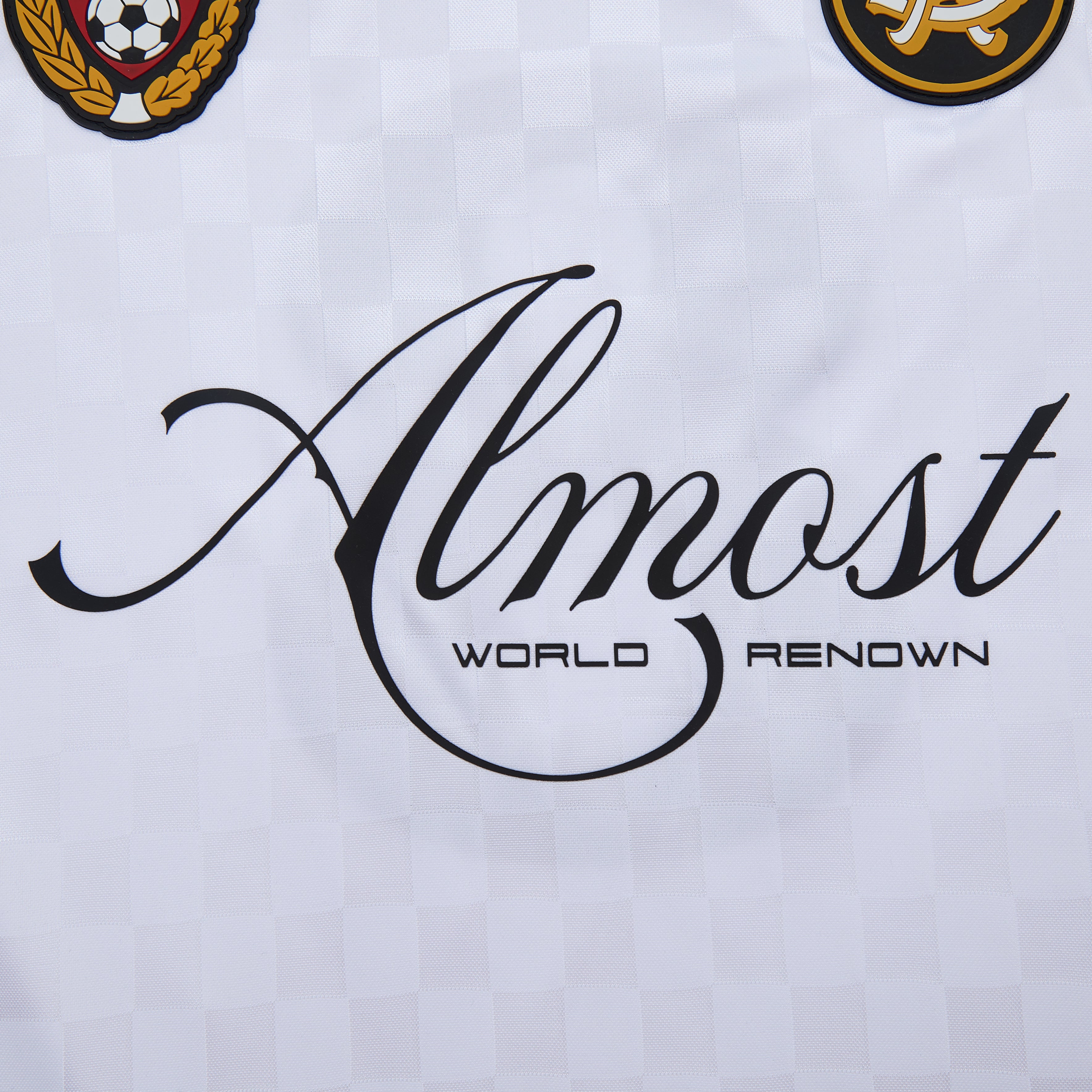 Text 'Almost World Renown' on a white background with two emblems at the top.