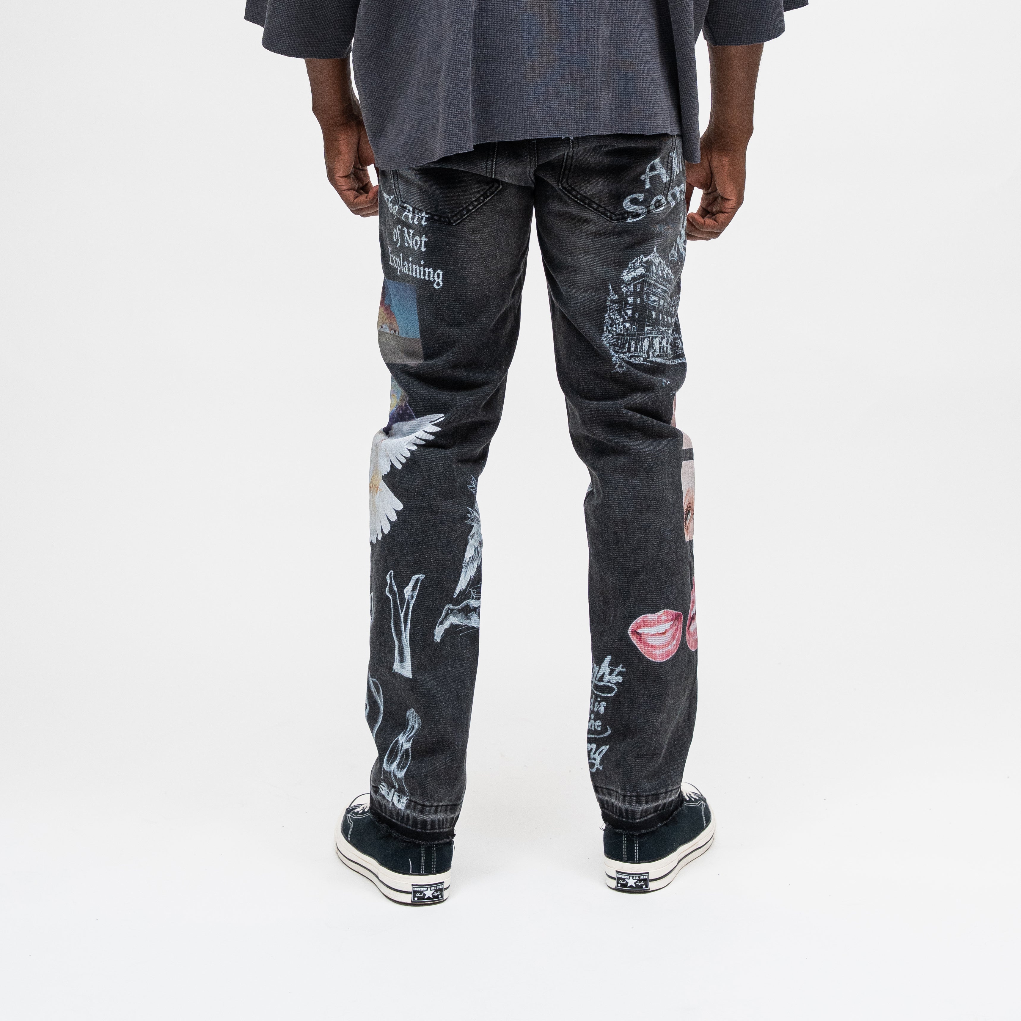 ALMOST SOMEDAY Gallery Denim Pant in Black, back view with The Art of Not Explaining text, architectural illustration, angel wings, and lips graphic