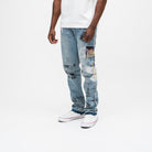 ALMOST SOMEDAY Gallery Denim Pant in Blue Wash, angled side view showing photo patches and This Is On You text graphics
