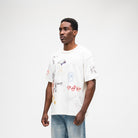 ALMOST SOMEDAY Gallery Tee in Cream, angled front view showing collage print detail and sleeve graphic