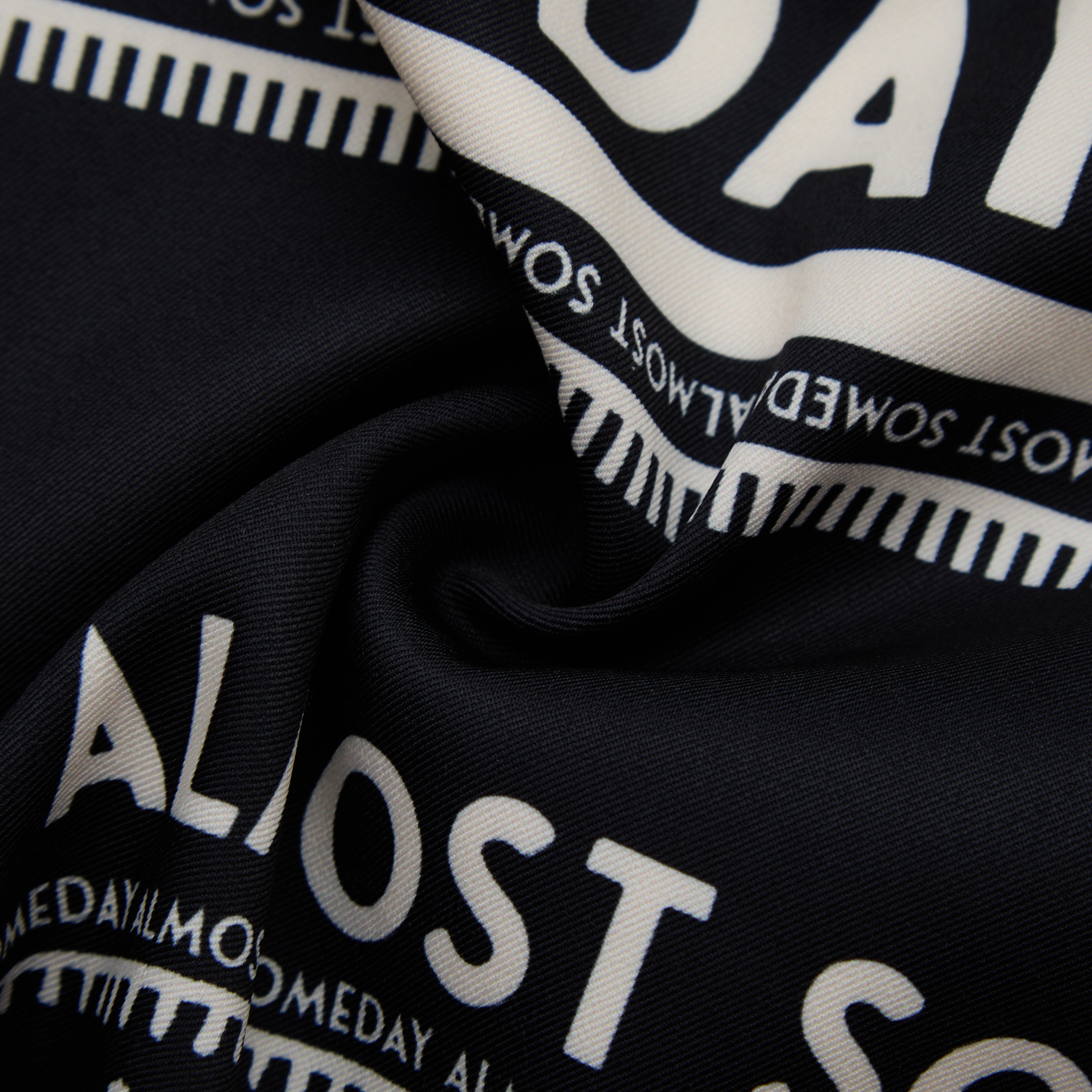 Close-up of black fabric with white text pattern