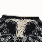 Black shorts with white floral and text pattern on a white background