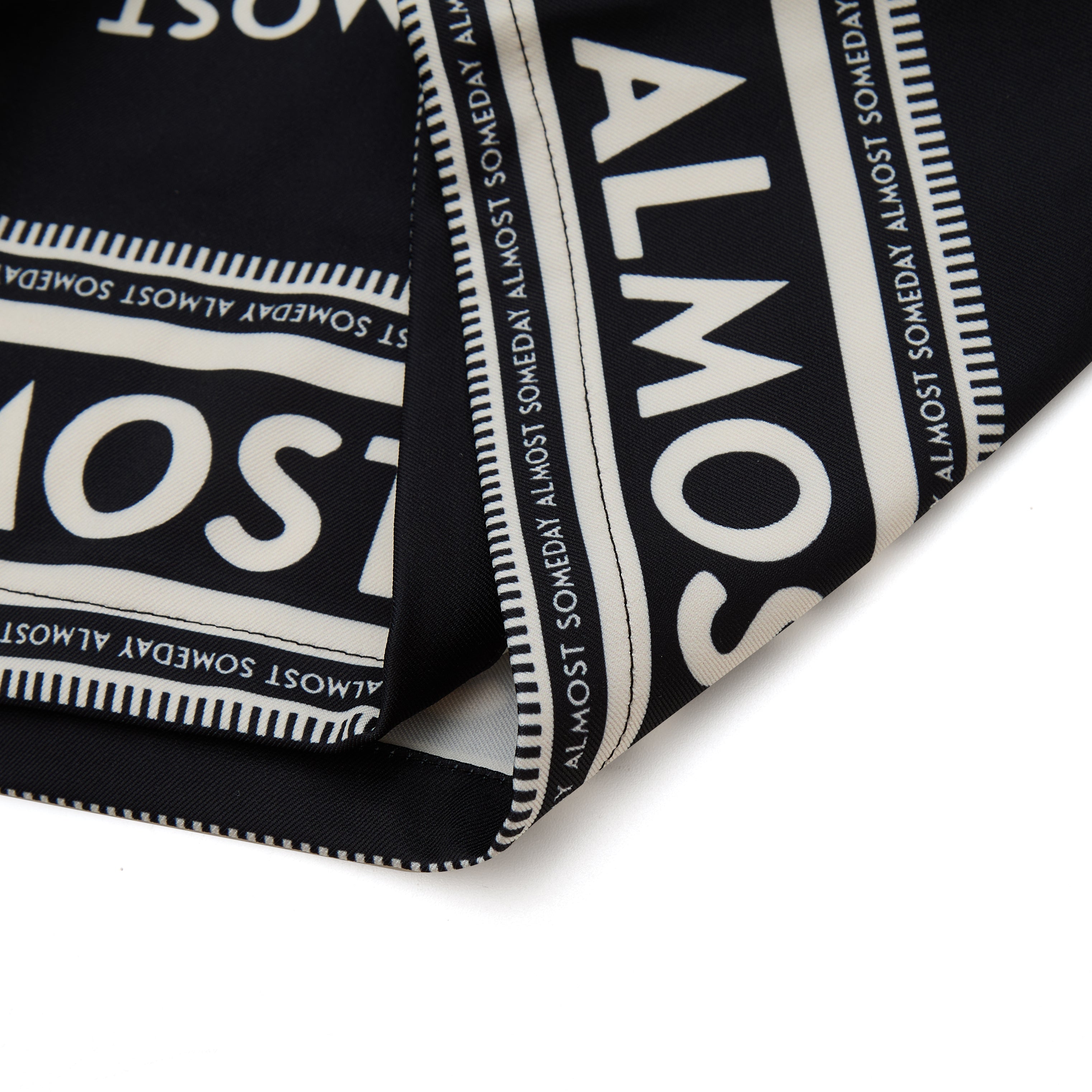 Black fabric with white text pattern on a white background
