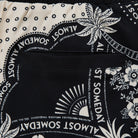 Close-up of a black and white patterned fabric with text and floral designs.