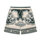 Beige shorts with green pattern and 'Almost Someday' text on a white background