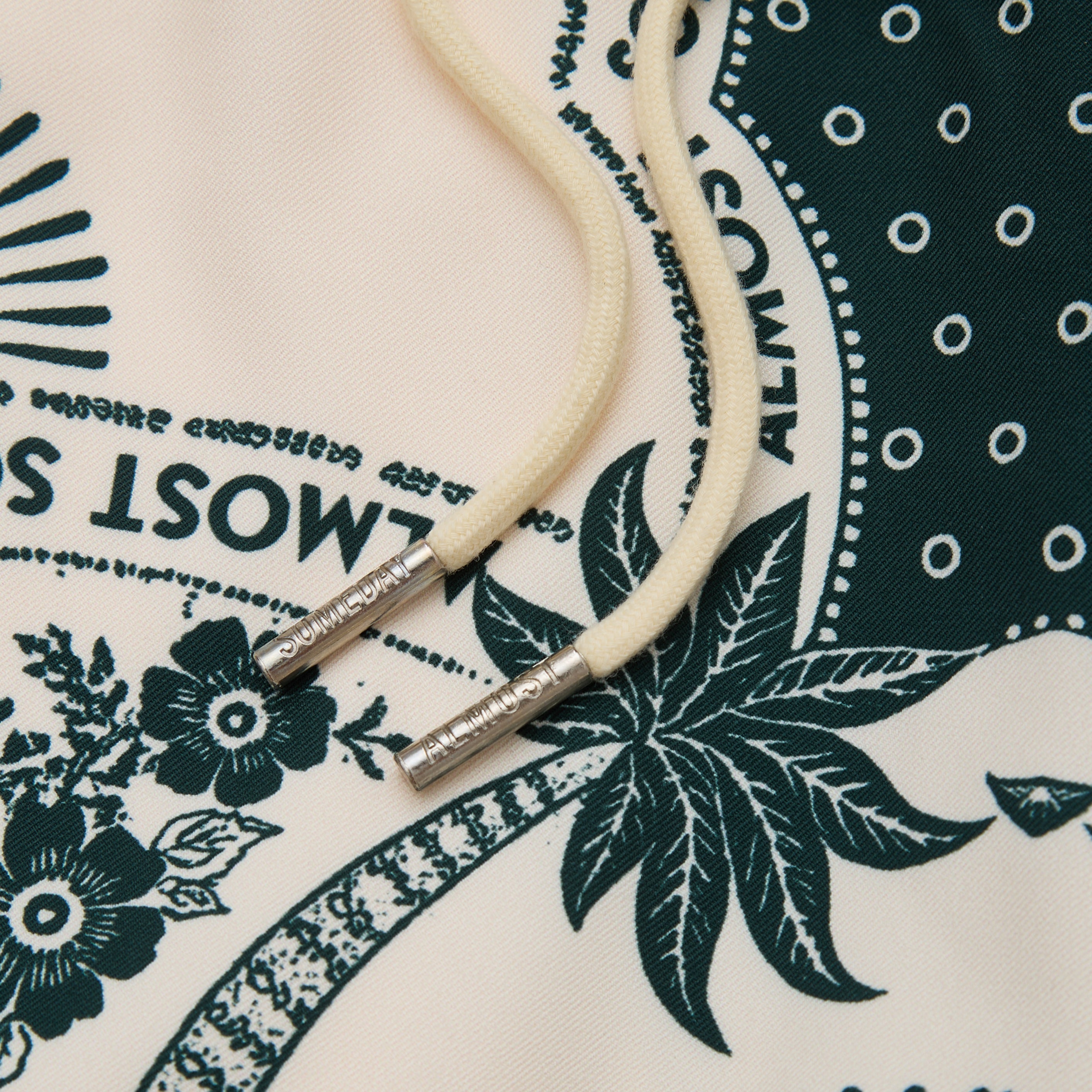 Close-up of a beige cord with silver ends on a patterned fabric background