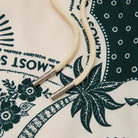 Close-up of a beige cord with silver ends on a patterned fabric background