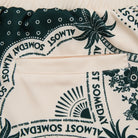 Close-up of a fabric with 'Almost Someday' text and floral patterns.