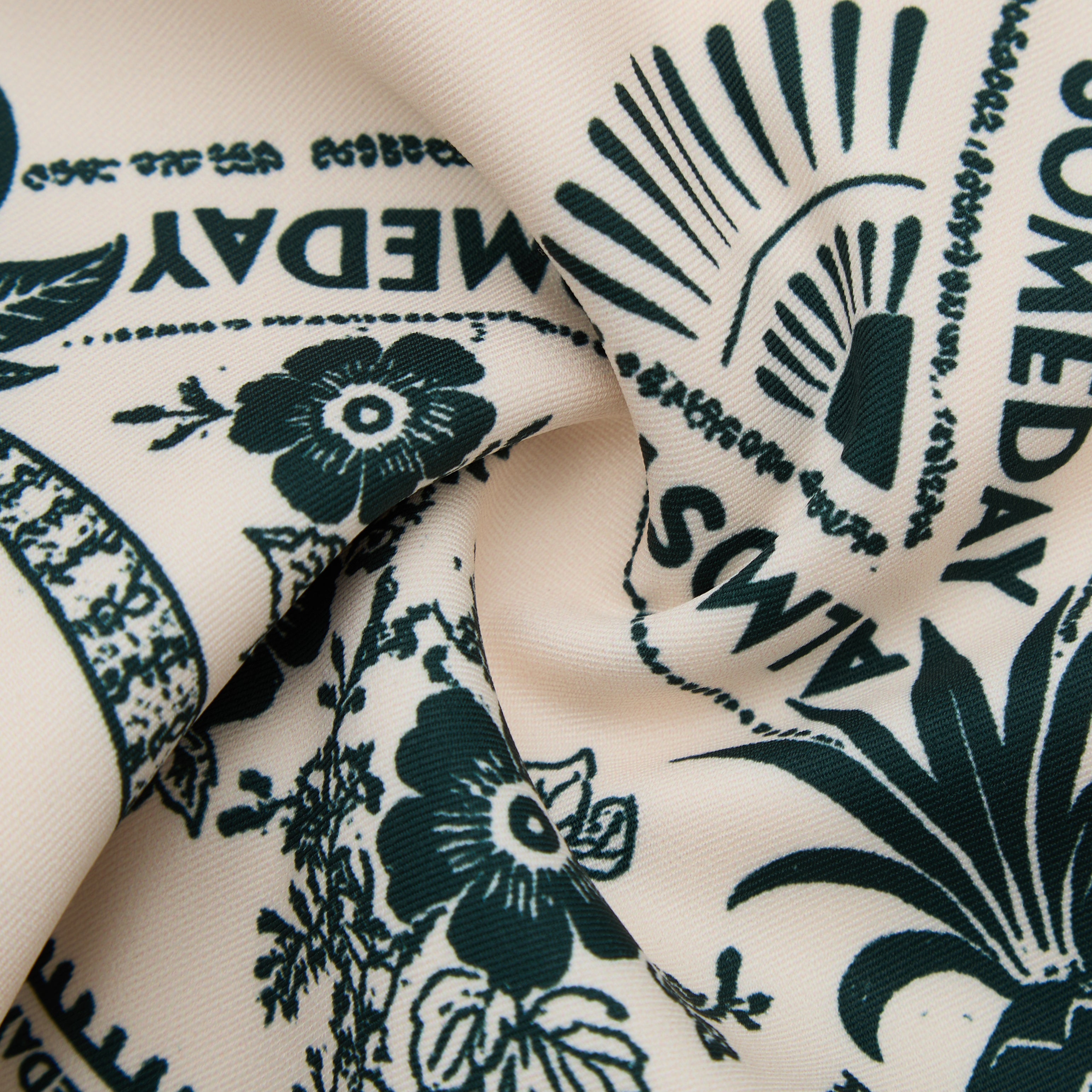 Close-up of fabric with dark blue floral and text pattern on a beige background