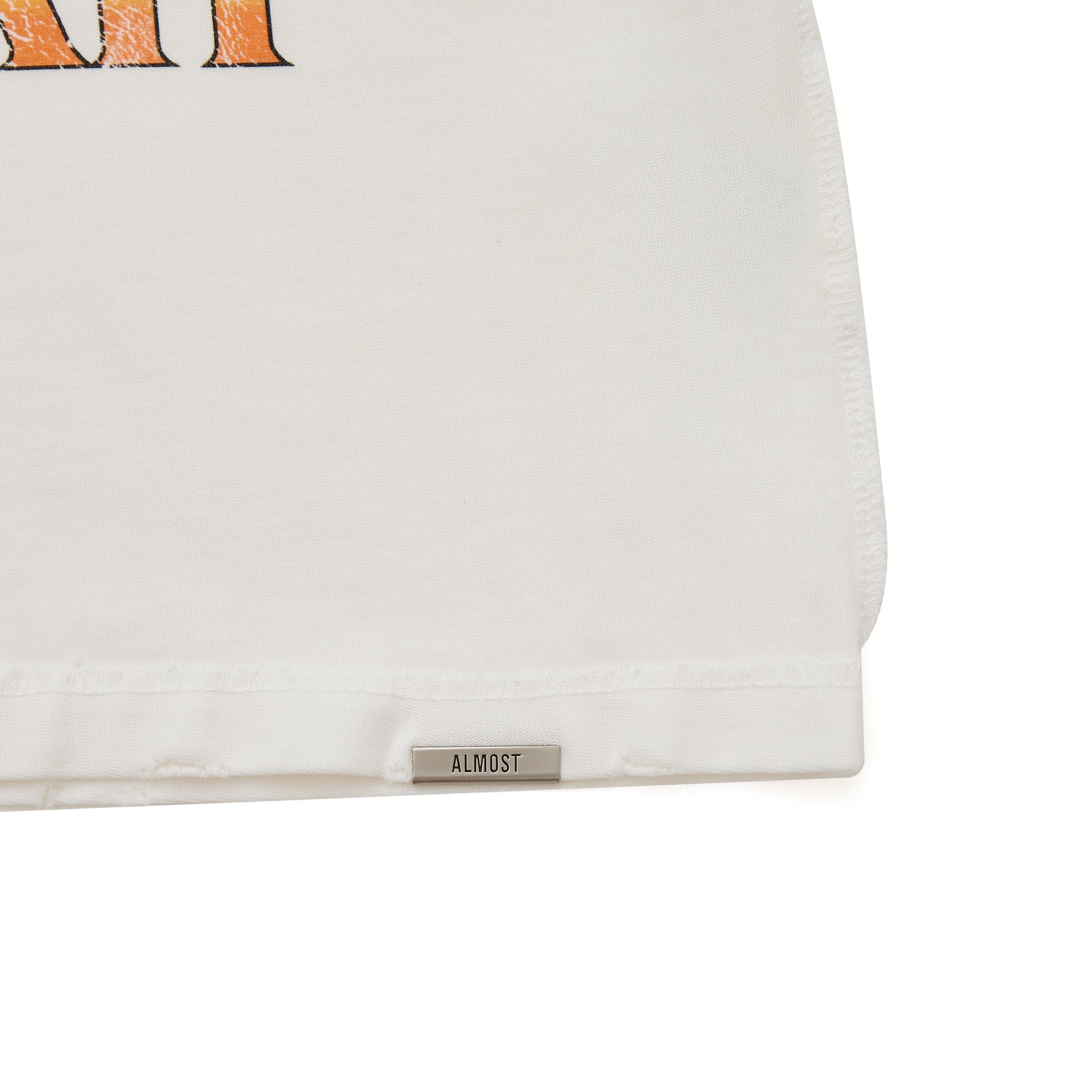 Close-up of a cream garment with a brand label on a white background