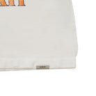 Close-up of a cream garment with a brand label on a white background