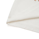 Close-up of a cream fabric with a subtle pattern on a white background