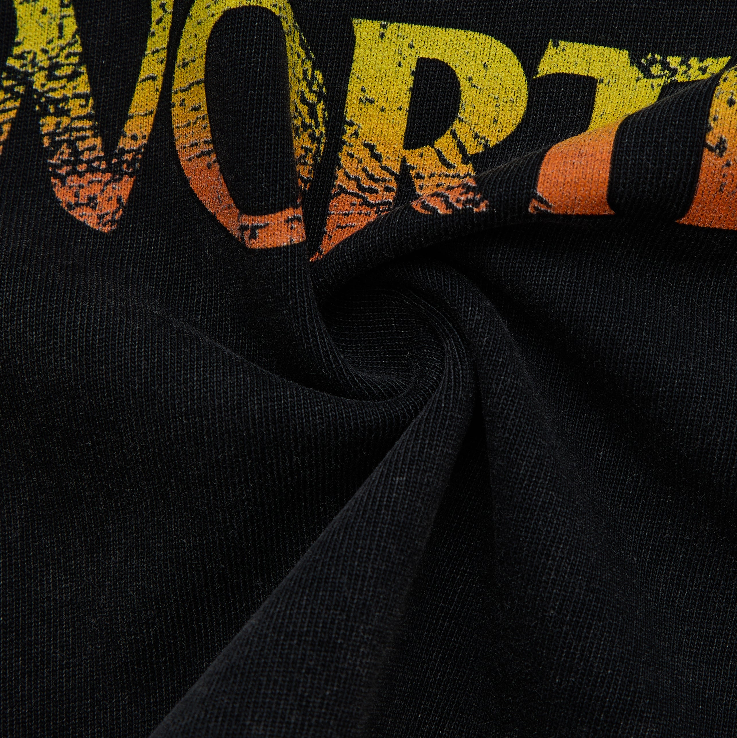 Black fabric with graphic close up printed in orange and yellow.