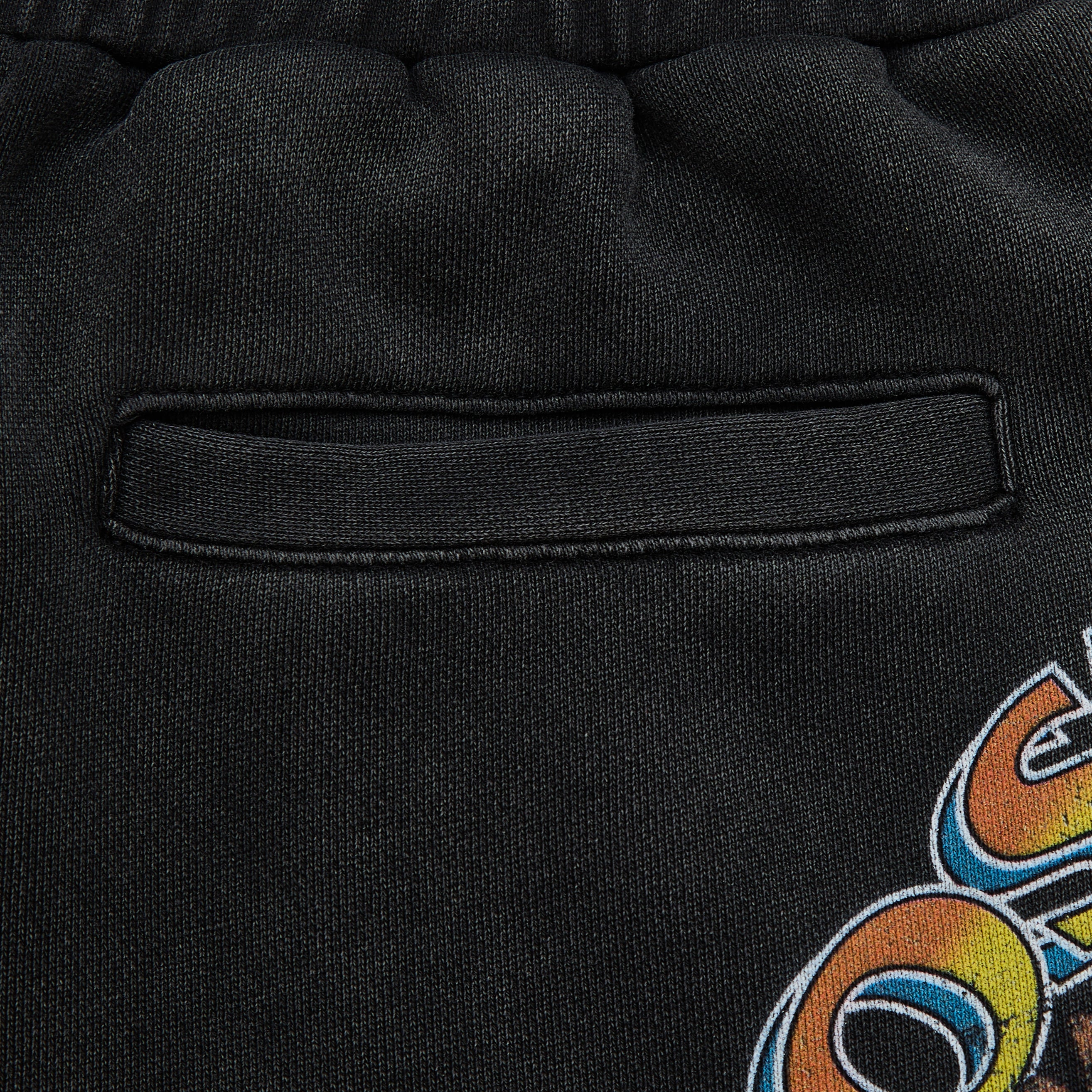 Close-up of a black sweatshirt with a colorful logo on the sleeve.