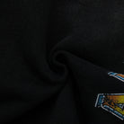 Close-up of a black fabric with a colorful logo on a dark background