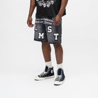 ALMOST SOMEDAY Letterman Denim Jort in Black, angled front view showing block letter appliqué detail, basketball star, and raw frayed hem