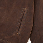 Close-up of a brown fabric with a pocket detail on a white background