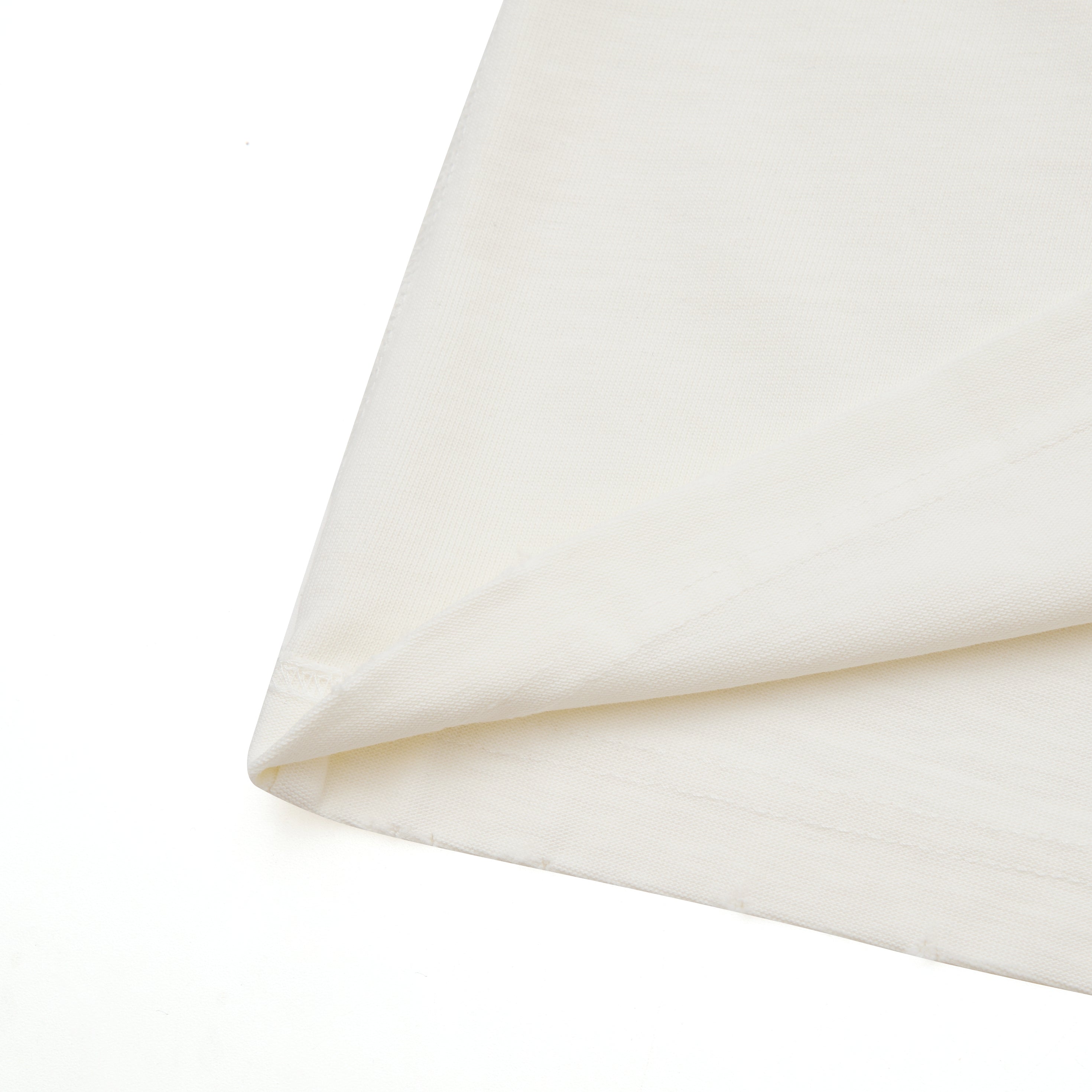 Close-up of cream fabric with a subtle texture on a white background