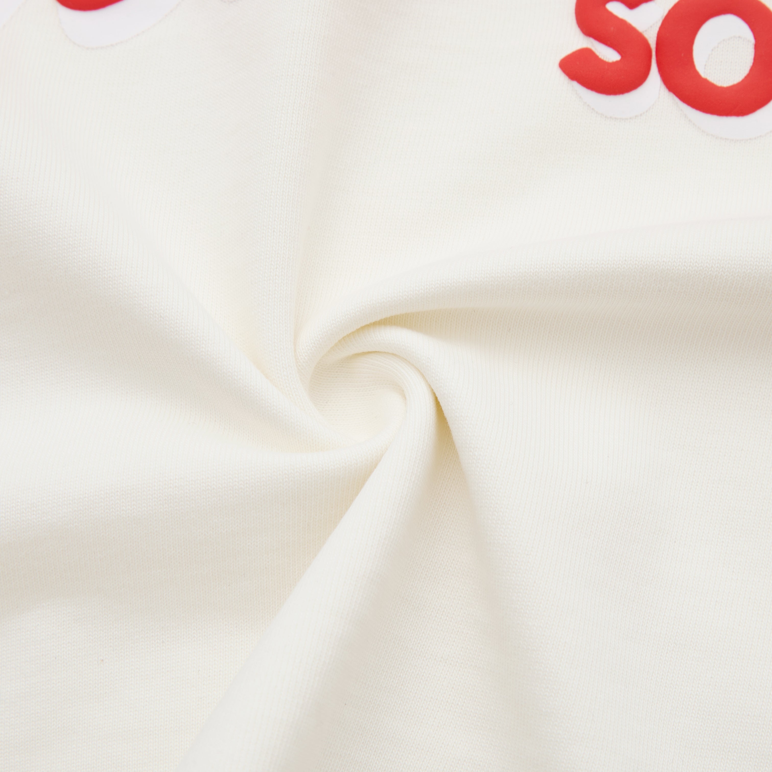 Close-up of cream fabric with red text on a white background