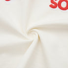 Close-up of cream fabric with red text on a white background
