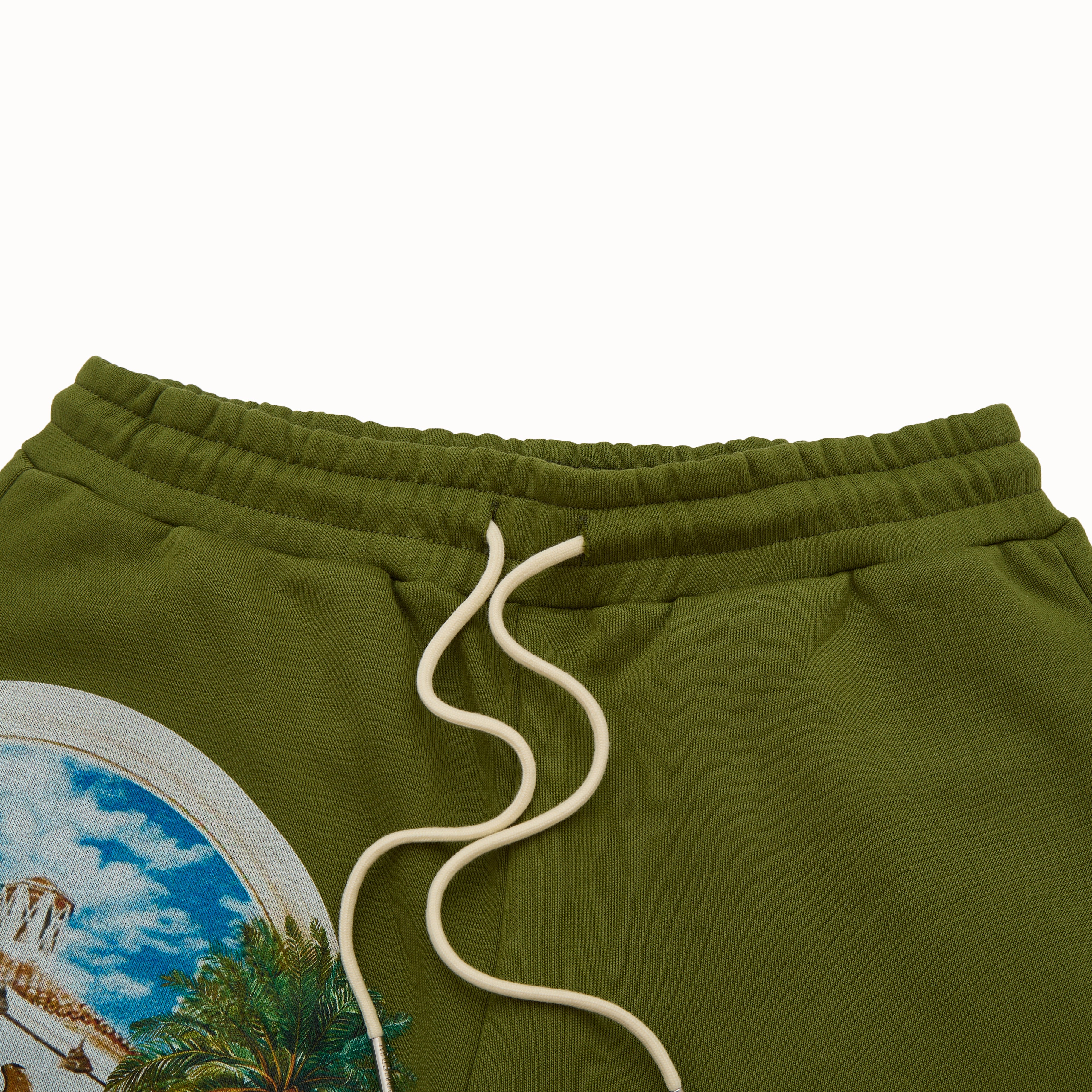 Olive green sweatpants with a scenic print on the leg and white drawstring.