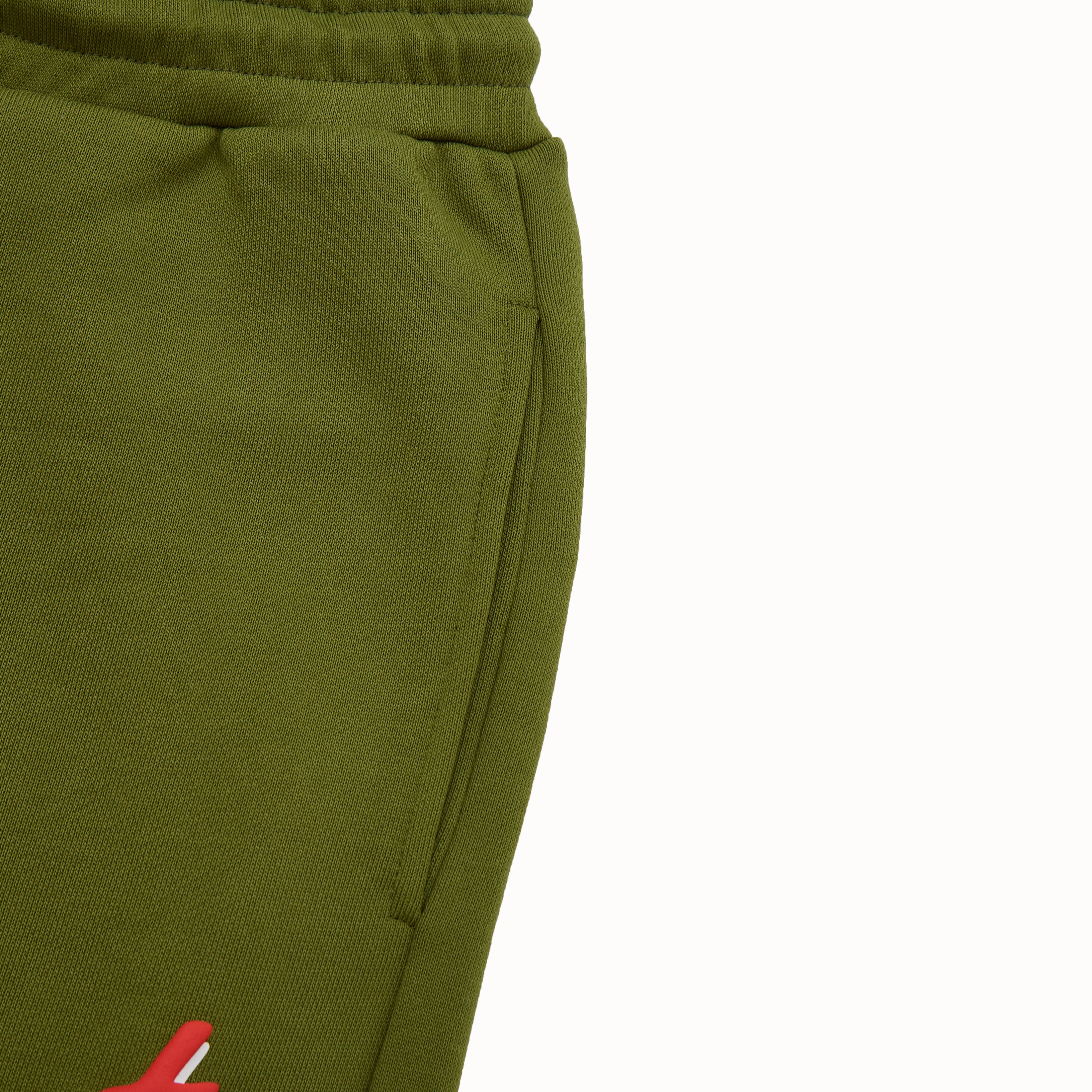 Close-up of olive green sweatpants with a red logo on a white background