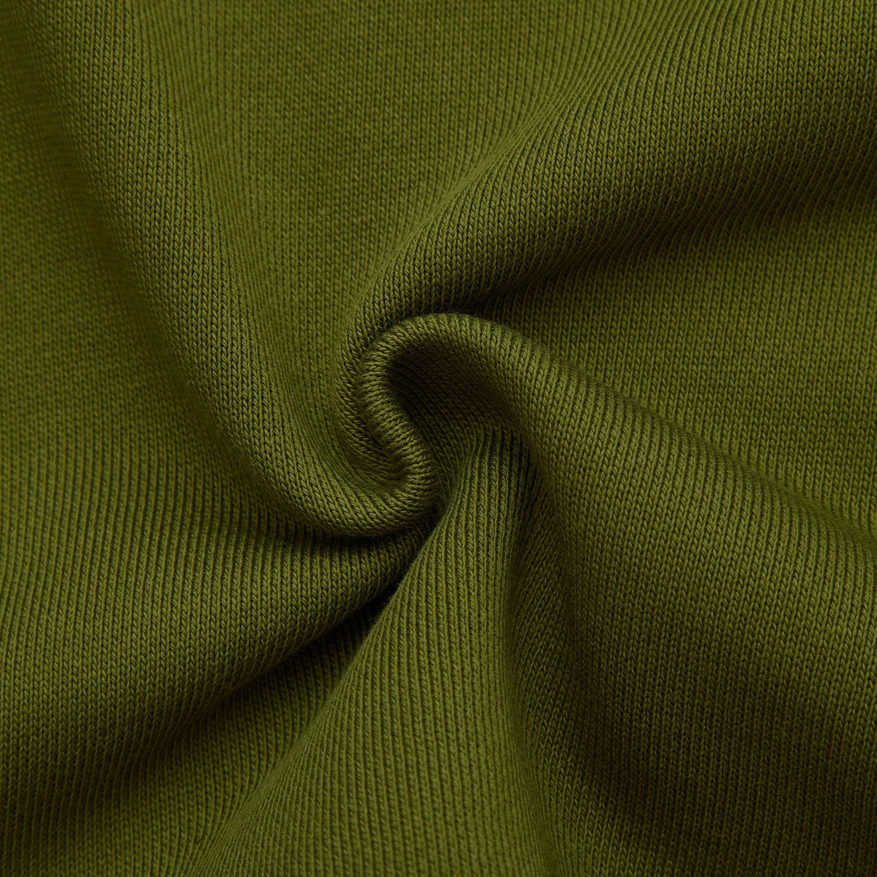 Close-up of olive green fabric with a textured pattern