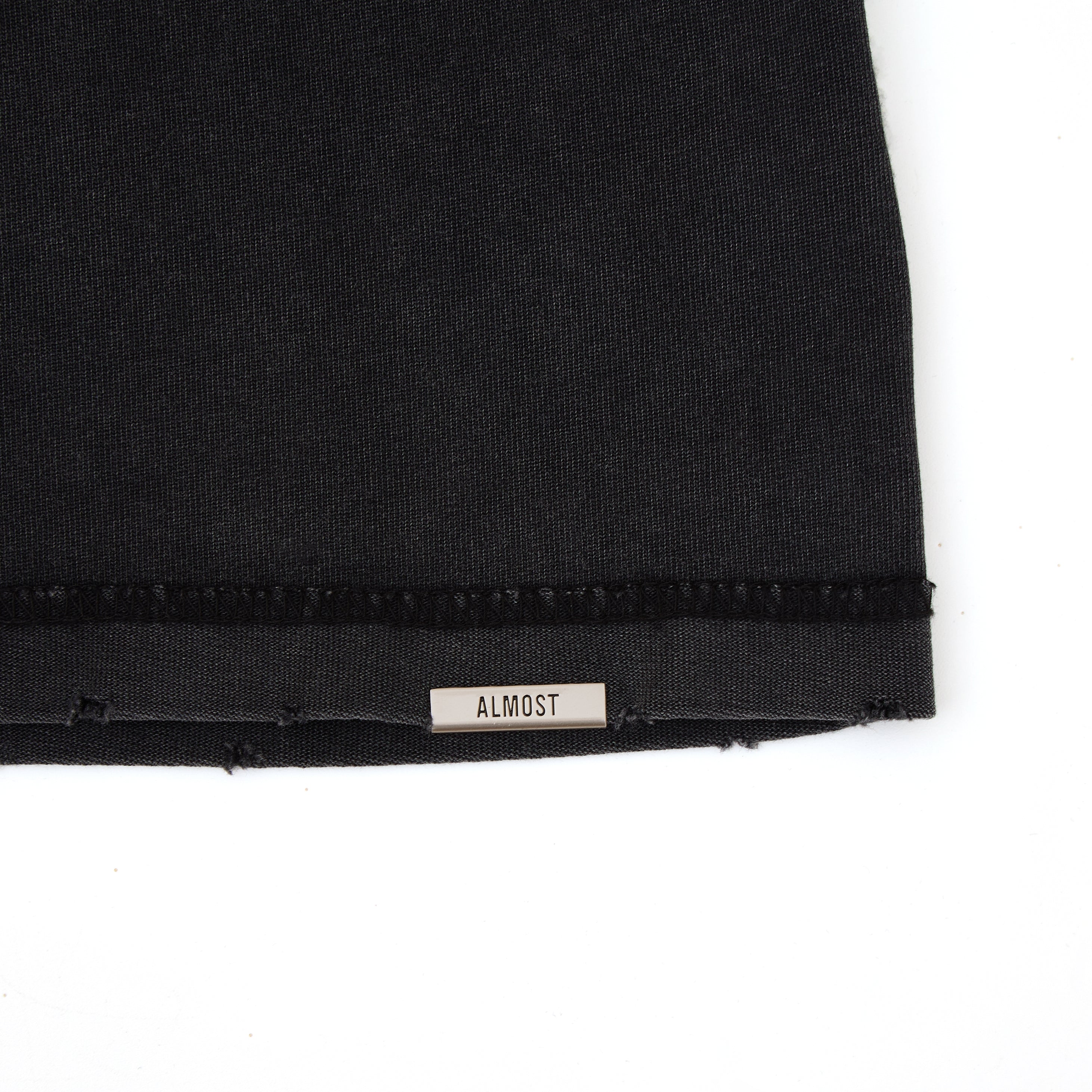 Black fabric with a 'ALMOST' label on a white background